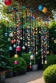 colorful wind chimes hanging from a tree in a garden