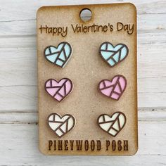 four heart shaped pins with the words happy valentine's day on them