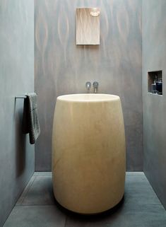 a bathroom with a large round sink in the middle and a towel hanging on the wall