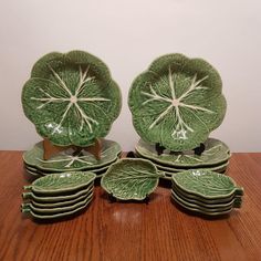 a stack of green plates sitting on top of a wooden table next to each other