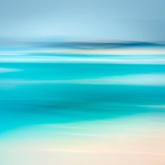 blurry photograph of the ocean with blue and white colors on it's surface