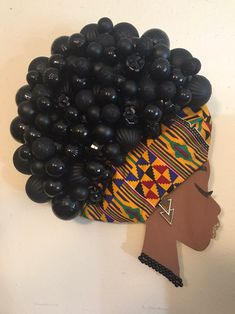 a woman's head made out of black balloons and other items on the wall