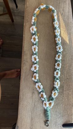 a wooden table topped with a flower necklace