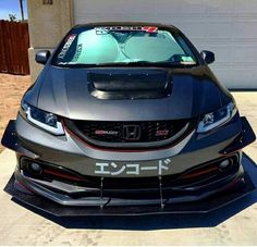 the front end of a gray honda civic type car with japanese writing on it's hood