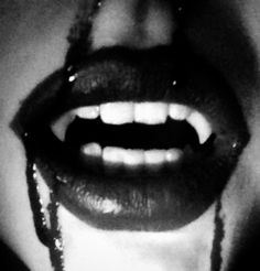 a woman's mouth with chains on it and her tongue hanging out to the side