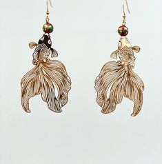 The cutest pair of gold koi earrings accented with gorgeous red oriental style beads. They measure 3 inches in length. Gold plated earrings hooks Koi Earrings, Elegant Gold Fish-shaped Earrings, Gold Fish-shaped Earrings With Fish Hook, Gold Fish-shaped Earrings, Gold Fish-shaped Pierced Earrings, Gold Feather Earrings, Gold Feathers, Gorgeous Leather, Blush Color