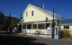 an old yellow house with a bicycle parked in front