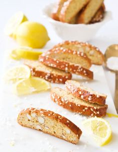 sliced lemon and sesame seed bread on a cutting board with two bowls of lemons in the background