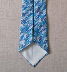 a blue tie with cars on it and a white pocket square in the bottom corner