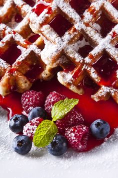 waffles, berries and powdered sugar on a white plate