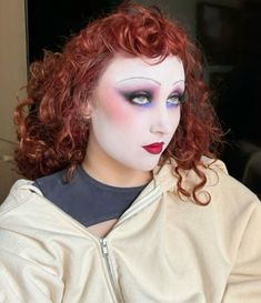 a mannequin with red hair and blue eyeshades wearing a white jacket