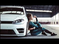 a woman sitting on the ground next to a white car with her hand on her head