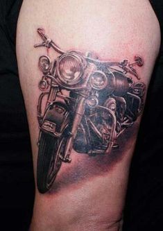 a black and white photo of a motorcycle on a woman's arm with tattoos