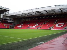 an empty soccer stadium with red seats