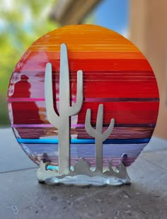 a glass plate with two cactus on it sitting on top of a cement floor next to a building