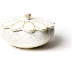 a white bowl with gold dots on the rim and lid is sitting on a white surface