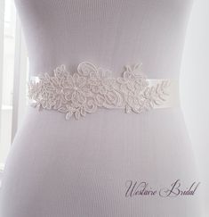 "This vintage inspired bridal sash is embellished with delicate floral lace for an elegant finish to your bridal attire. The sash is made with double faced Ivory satin ribbon 1.5\" wide and is 3 yards long. Beautiful addition to your wedding gown. PROCESSING: Please allow 3-5 business days for production. Also be sure to leave the date you require your order or your wedding date. For rush order, please convo us before placing your order. SHIPPING: Order will be shipped via USPS First Class Mail Lace Bridal Belt With Sashes For Wedding, White Lace Wedding Sash, Lace Bridal Belt For Ceremony, White Embroidered Bridal Belt For Wedding, Lace Bridal Belt With Lace Trim For Wedding, Cream Bridal Belt With Sashes For Wedding, Camping Wedding, Bridal Sash Belt, Bridal Attire