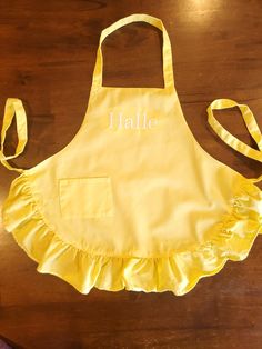 a yellow apron with the word hale on it sitting on top of a wooden table