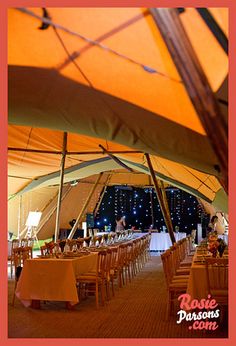 the inside of a large tent with tables and chairs set up for an outdoor event