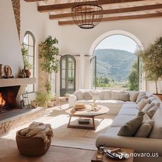 a living room filled with furniture and a fire place in front of a window covered wall