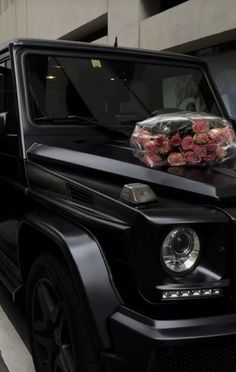 a black car with flowers on the hood