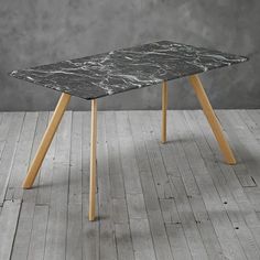 a marble table with wooden legs on a wood floor