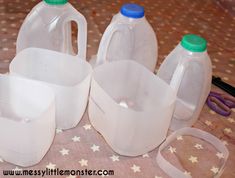 three plastic jugs are sitting on a table with scissors and other items around them