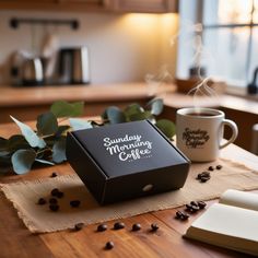 a coffee box sitting on top of a wooden table next to a cup of coffee