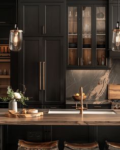 a kitchen with black cabinets, marble counter tops and wooden stools in the center