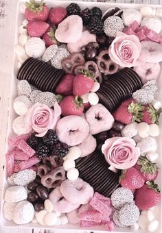 a box filled with lots of different types of doughnuts and strawberries on top of each other