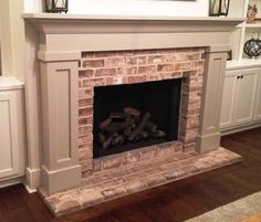 a brick fireplace in a living room with white cabinets