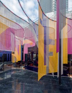 an artisticly designed building with pink, yellow and purple curtains