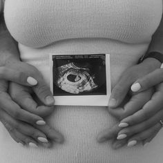 a pregnant woman holding her stomach with both hands on the belly and an x - ray image