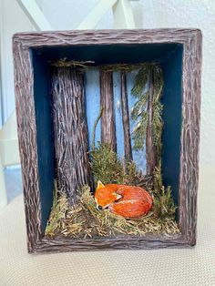 a small wooden frame with an orange fox in the woods