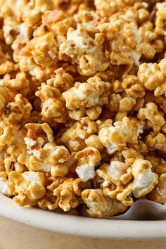 a bowl filled with caramel popcorn on top of a table