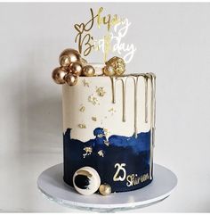 a white and blue cake with gold decorations