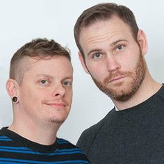 two men standing next to each other in front of a white background