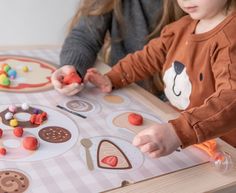 two children playing with candy at a table