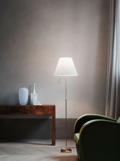 a living room scene with focus on the floor lamp and chair next to the table