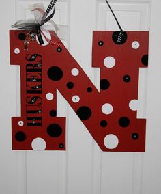 the letter n is made out of red and black polka dot paper with a bow