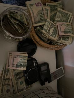 a pile of money sitting on top of a table next to a bowl filled with cash