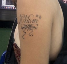 a woman with a tattoo on her arm that says mum in cursive writing