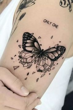 a woman's arm with a butterfly on it and the words only one written in black ink