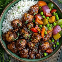 a bowl filled with rice, meat and veggies on top of a wooden table