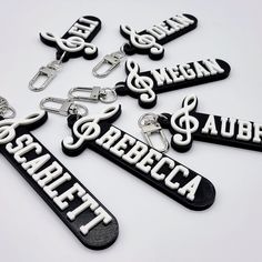 black and white keychains with musical notes on them are arranged in the shape of letters