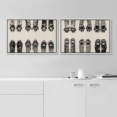 two black and white pictures hanging on the wall next to each other in a room