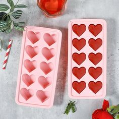 two heart shaped ice trays sitting on top of a table next to a red rose