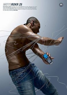 a man holding a cell phone in his right hand while wearing jeans and no shirt