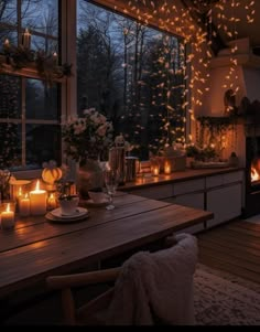 a dining room table with candles lit up in front of the window and windowsill