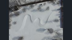 an aerial view of snow covered ground with trees